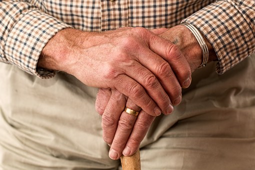 care homes for elderly man with hands folded and walking stick
